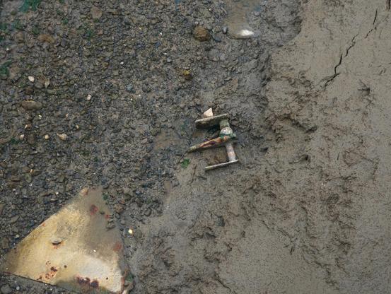 A metal object lying on mudflats looks a bit like a Star Wars X Wing starfighter spacecraft