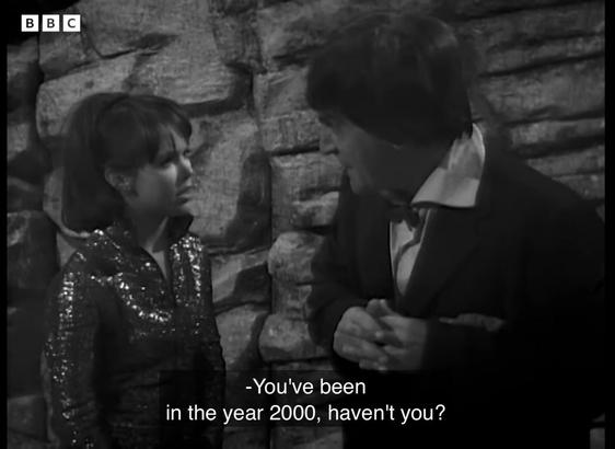 Black and white screen shot from Doctor Who, The Mind Robber

Zoe (Wendy Padbury) and the Doctor (Patrick Troughton) stand before a rock wall. Zoe wears a sparkly jump suit. The Doctor wears a rumpled suit and bow tie. 

Zoe says “You’ve been in the year 2000, haven’t you?”