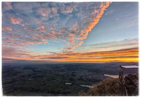 View from a mountain across a valley. Colorful clouds due to sunrise.