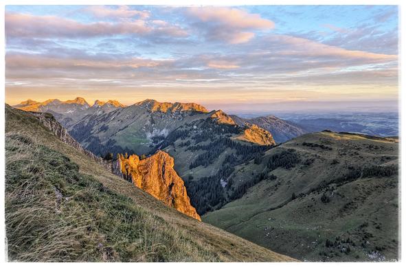 Mountain range, partly lit by the rising sun.