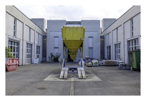 Une machine dont je ne sais pas la fonctionnalité, devant le bâtiment MXH de l'EPFL. Comme une gigantesque rampe d'accès pour véhicules avec un grand entonnoir jaune au-dessus. Toute information bienvenue.