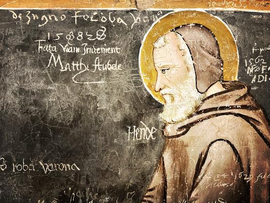Inscription de noms gravés sur les fresques des murs de l’église