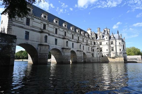 Ein Gebäude auf einer steinerne  Brücke führt zu einem Schloss