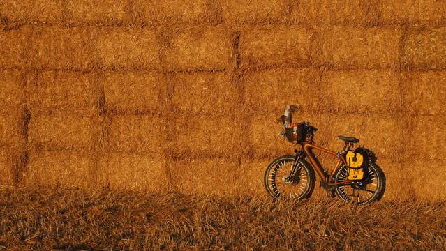 Fahrrad vor einer Wand aus Strohballen im goldenen Abendlicht
