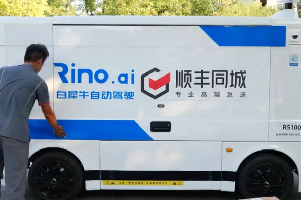 <p>中国の無人配送車スタートアップ「白犀牛（WHITE RHINO）」がこのほど、シリーズBでの追加調達が完了し、累計調達額が約5億元（約100億円）に達したと発表した。物流大手の順豊控股（SFホールディング）や線性資本（Linear Capital）などの既存株主が追加出資したほか、新たに以駿資本や三六零基金なども出資した。SFホールディングが2024年8月の最初の出資以降、1年間に2回の追加出資を実施したことにも注目が集まる。</p>
<p>白犀牛は2019年に設立され、無人配送車とフルスタックの無人配送ソリューションを展開している。共同創業者の朱磊氏と夏添氏は、いずれもネット大手の百度（バイドゥ）の自動運転部門出身。25年3月にはトラック大手の東風商用車の元社長、黄剛氏を総裁に迎えて経営体制を強化した。</p>
<p>乗用車向けの先進運転支援システム（ADAS）の普及により、LiDARをはじめとする自動運転の必須部品の価格は大幅に低下した。また、政府も物流分野での無人車活用を推進しており、現時点で103都市が無人配送車の公道走行を許可している。大規模な公道テストや商用運行が進み、無人配送車の活用によるコスト低減・効率向上の効果が実証されつつある。</p>
<p>白犀牛はスーパーマーケットの商品配送から事業をスタートし、業界大手の永輝超市やアリババ系の盒馬（Hema）と提携した。2023年からは「ラストワンマイル（末端配送）」に重点を置き、企業の配送拠点から宅配ステーションや消費者の手元まで、通常10キロメートル以内の配送を手がけ始めた。これまでの配送では小型トラックなどで1日4〜5往復する必要があり、効率の低さや人件費などが課題となっていたが、無人配送車ならばこれらの課題を解決できる。</p>
<p>主力機種「R5」は、容積5500リットルの荷室に500個以上の荷物を積み込むことができ、1回のフル充電で120キロメートル走行できる。すでにSFホールディングや中通快递（ZTO Express）、極兔速逓（J&amp;T Express）、中国郵政（China Post）などの物流大手が導入し、中国国内100都市以上で活躍している。</p>
<p>現在、同社の無人配送車の稼働台数が急速に伸びている。朱磊・最高経営責任者（CEO）によると、2023年12月の100台足らずから、25年1〜3月期には200台に、4〜6月期には500台に、8月には1000台近くにまで増加した。26年の目標は、1日あたりの稼働台数5000台だという。</p>
<p>運営データからの計算では、無人配送車の導入で顧客の配送コストは3〜5割削減可能だ。湖北省武漢市の宅配事業者では、荷物1個あたりの平均コストを半減させたという。配送車が宅配ステーションまでの輸送を担うことで、配達員は住宅団地での集荷・配達に専念できる。さらに無人車は24時間稼働し、夜間も遠隔操作による配送が可能となる。</p>
<p>近く自動車規格に準拠した新型車の発表も予定している。新たなプラットフォーム（車台）を採用し、現行モデルよりもサイズも荷室容量も大きく、100キロメートル圏内の都市内物流や都市間輸送での活用を見込む。</p>
<p>朱CEOによると、今後は車両販売とソフトウエアのサブスクリプションサービスで収益を上げる計画で、販売台数が1万台に達すれば黒字転換を果たせる見込みだという。</p>
<p>＊1元＝約21円で計算しています。</p>
<p>（翻訳・田村広子）</p>