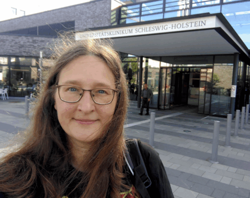 Selfie von einer Frau vor dem Universitätsklinikum Schleswig Holstein in Kiel