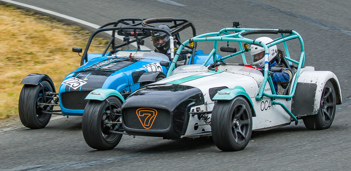 Me driving a white Caterham Seven, racing wheel-to-wheel against another Caterham.