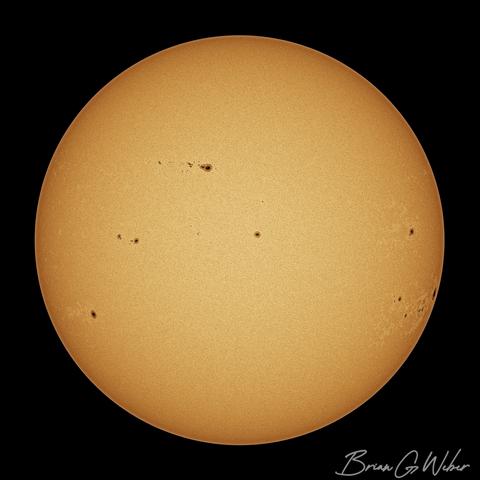 A monochrome full disk image of the sun colorized orange