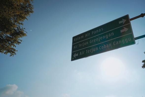 A street sign that says turn right to hotsprings and Grenjengan Waterfall and turn left to Coban Cangu waterfall