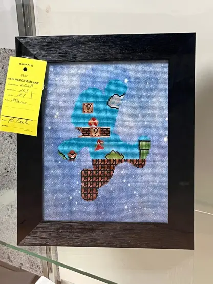 An image of a threaded design of level 1 from world 1 of Super Mario Bros. filling the silhouette of Mario in his iconic fist-up jumping pose.