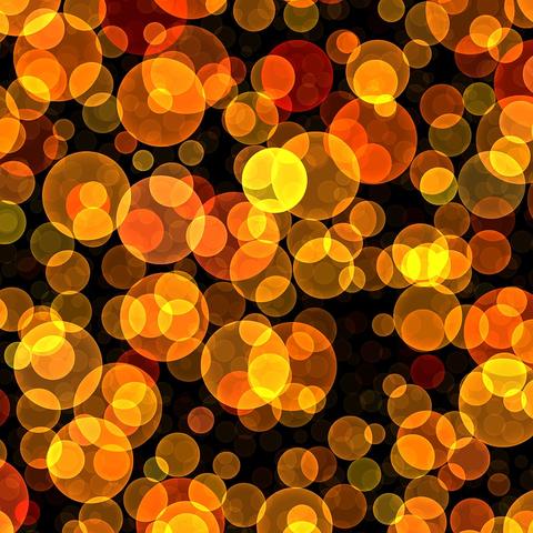 Przedstawiony obraz to grafika, która przypomina zbliżenie na świecące kule. Całość jest osadzona na czarnym tle, a te kule, czyli bąbelki, są różnej wielkości i mają różne odcienie, głównie w palecie od jaskrawej żółci, przez pomarańcz, aż po czerwień. Wydają się być lekko przezroczyste, nakładając się na siebie, co tworzy wrażenie głębi i trójwymiarowości. Można to skojarzyć z efektem bokeh, czyli z rozmytymi plamami światła, które często pojawiają się na zdjęciach z małą głębią ostrości.