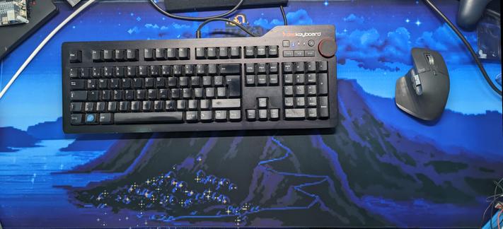 Tastatur und Maus auf einem Soft-Mousepad, welches eine Nachtszene aus dem Spiel "The Secret of Monkey Island" darstellt