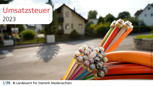 Umsatzsteuer, 2023. Das Bild zeigt Glasfaserkabel, im Hintergrund ist eine Wohnsiedlung zu erkennen.