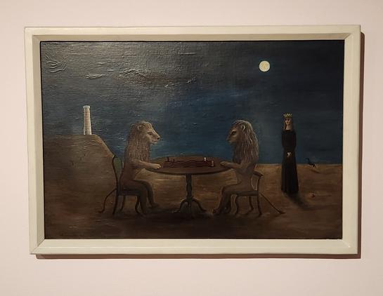 Seated at a table are two lions, facing each other, playing chess. There is a woman in a long black dress off to the left, in the background, and avove the dark horizon rises a full moon. On a hill to the far left is a white turret of a castle.