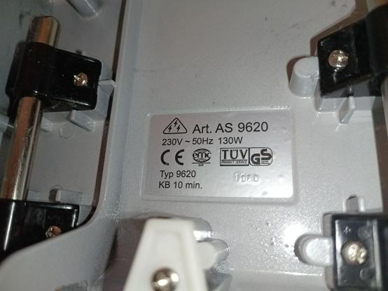 The underside, showing the cast metal housing and some steel clamps holding sliding rods for the adjustable thickness gauge. The type label reads AS 9620 and some approval stamps.