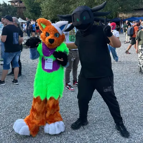 Another photo of me in a the aforementioned partial fursuit of my axolotl fursona alongside another fursuiter (@8scatolawii8 on Instagram) with yet another canine fursuit