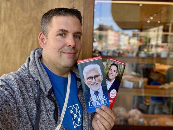 Jens Matheuszik mit Flyern von Jörg Lukat und ihm selbst (und dem von Barbara Menke)