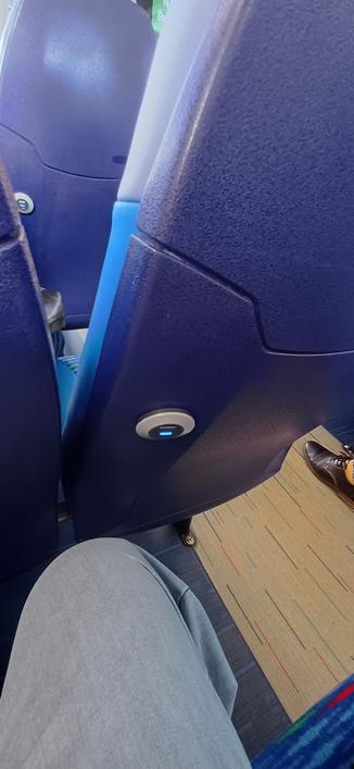 Back of a blue bus seat. With usb charger
