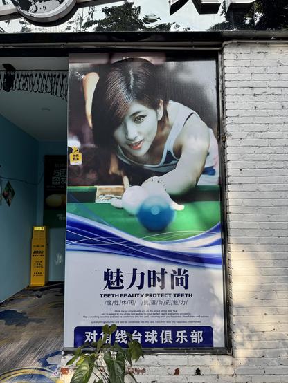 A sign on a wall of a woman playing billiards. Underneath are some Chinese words, and the phrase TEETH BEAUTY PROTECT TEETH. What is it advertising? A bar, I _think_. A passageway is on the left, leading to … either billiards or dentistry, I guess. Is it safe?