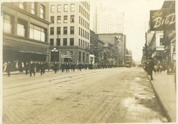 Striking street car workers walk east together on Superior street with the Glass Block department store