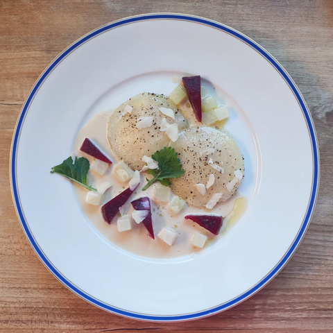 Auf einem Teller 2 Ravioli aus dünn gehobeltem Kohlrabi, Ecken von Roter Bete, Kohlrabe-Würfeln und Sauce
