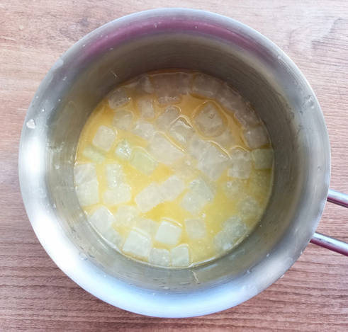 kleine Kohlrabi-Würfel in flüssiger Butter in einem kleinen Topf.