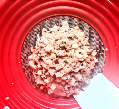 gegarte Pilz- und Schalottenwürfel auf einem Passiersieb