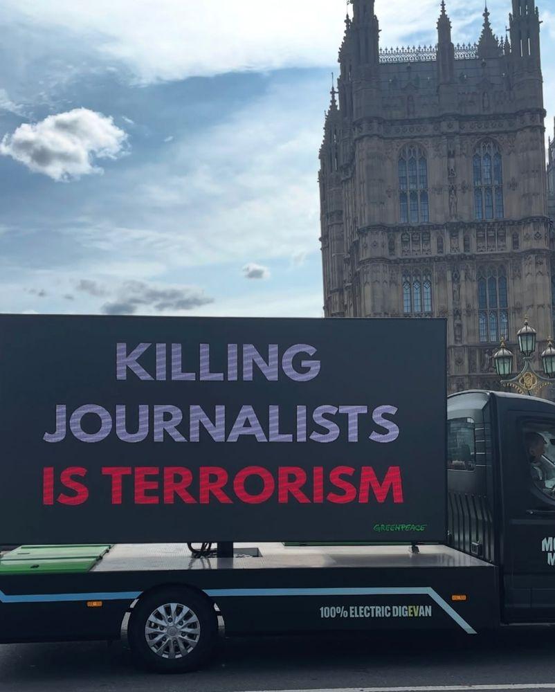 Greenpeace electric Truck showing the text  KILLING JOURNALUSTS IS TERRORISM in London