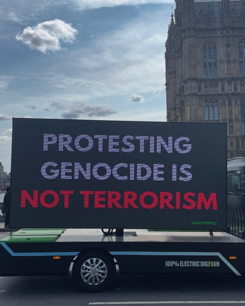 Greenpeace electric Truck showing the text  PROTESTING GENOCIDE IS NOT TERRORISM in London