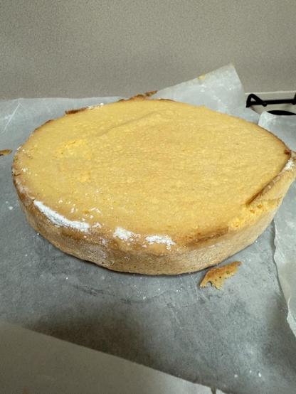 Freshly baked sponge cake cooling on a cake rack.