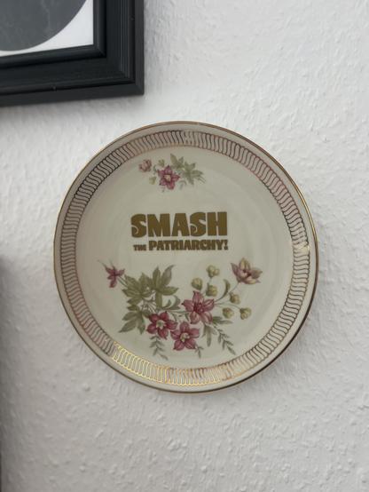 Teller mit Bumenmotiv, Goldrand und Smash the Patriarchy Aufdruck.