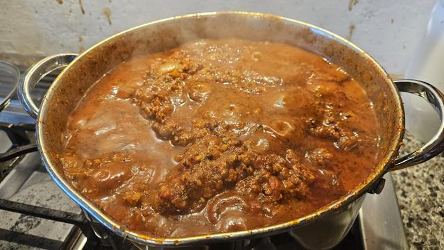 A big pot of meat sauce for lasagna, all red, steaming and bubbling like a volcanic mud pot of yumminess.