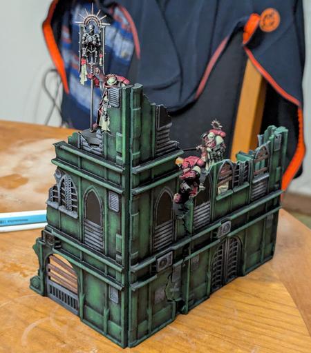 Painted Warhammer 40k scenery. A ruined green building with three space marines standing in it.