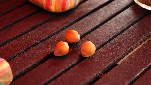Drei Haselnüsse auf einem Holztisch aus Latten