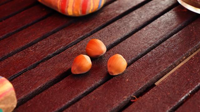 Drei Haselnüsse auf einem Holztisch aus Latten