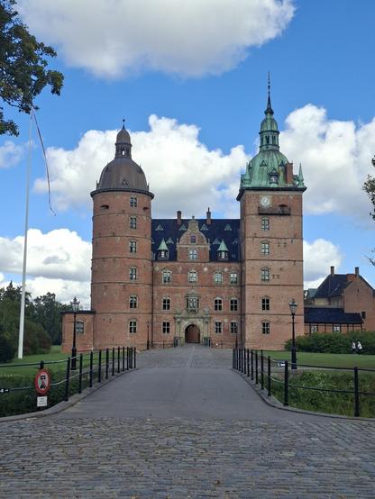 Voorkant van een kasteel nabij Køge in Denemarken. Vaarroute bakstenen, twee grote torens links en rechts, beide met eene bol metalen dak met een puntig torentje er op. Middenin een rechthoekig deel met een poort. Ervoor een brug over een slotgracht.