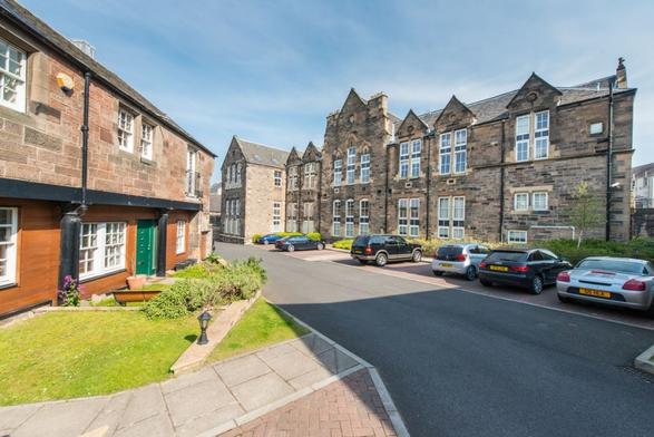 The rear of the redeveloped school, with the playground turned over to car parking. The low structure on the left was the block containing the workshops and sewing room. Picture via S1 Developments.