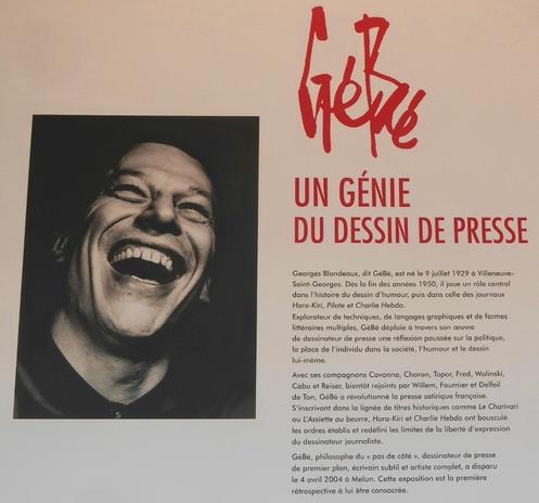 Une affiche de l'Expo "Gébé, un génie du dessin de presse" avec à gauche une photo-portrait de GéBé, à droite un texte synthétique du parcours de Gébé dans le monde du dessin de presse aux côtés de ses compagnons Cavanna, Choron, Topor, Fred, Wolinski, Cabu et Reiser, Willem, Fournier et Delfeil de Ton, presse satirique, politique entre autre.