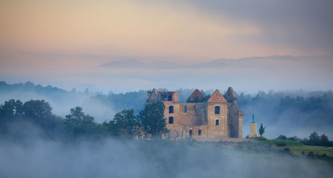 Ruins of Discalced Carmelite monastery in Zagorz, Poland seen through the morning fog in the mountains