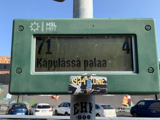 Bussipysäkin näyttö, jonka alaosassa lukee tiedotteen osa: ”Käpylässä palaa”.