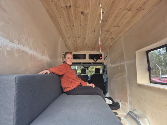 Varvara sitting on a couch in a van.