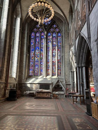 Beautiful, super tall stain glass window, the predominant colour of which is blue.