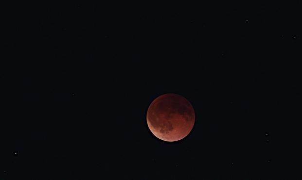 A telephoto (300mm) of eclipsed blood Moon, a wider shot showing stars on the sides of it.