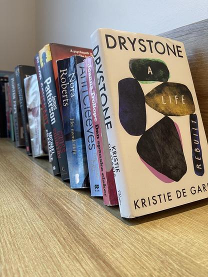 Kristie’s Drystone bookends a row of summer readings other guests have left. Browsing the other books, I think, Kristie’s physical a lightweight among them, but emotionally … not so!