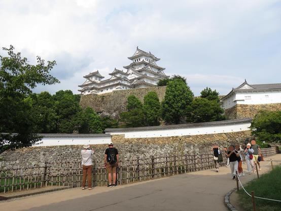 Long shot from the same place as the previous image.
The tourists are looking at the building over the water moat.