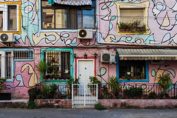 Colorful facade with abstract murals and plants.