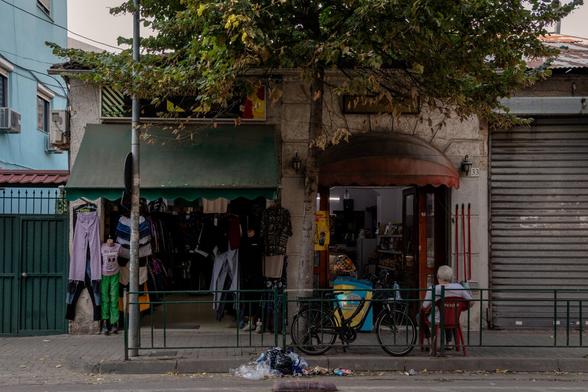 Small neighborhood shop with a man sitting outside.