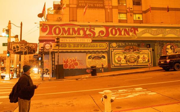 A photo of sf during the orange sky day: man standing along van ness