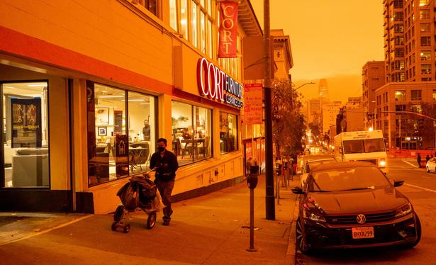 A photo of sf during the orange sky day: post man walking near van ness