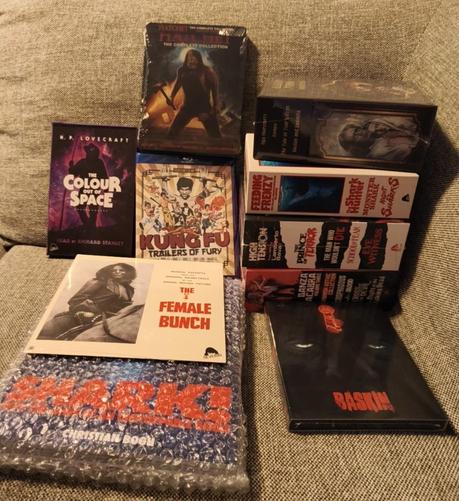 A whole bunch of blurays and bluray boxes, a tape book, a vinyl single and a book about Jaws ripoffs. The movies are: Hatchet collection, Baskin (UHD), Kung fu trailers of fury, High Tension Lamberto Bava movie box set, Feeding frenzy (Italian Jaws ripoffs box set), The female bunch 7 inch single and a box of Russian fantasy movies
